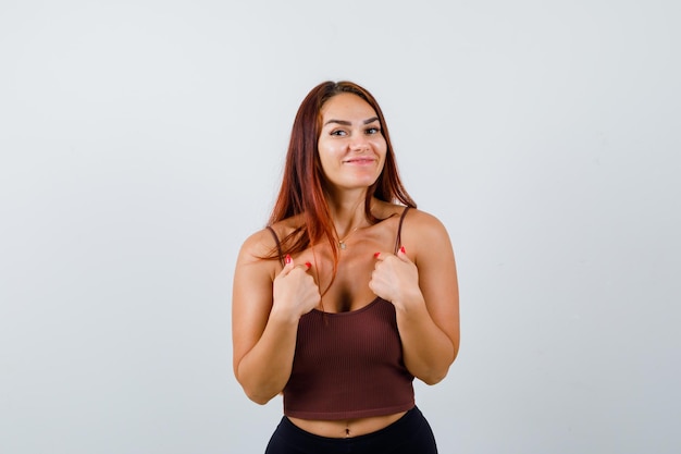 Jeune femme aux cheveux longs dans un haut court marron