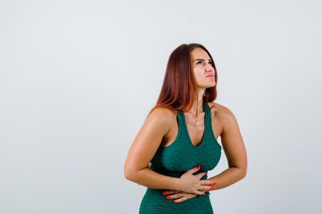 Jeune femme aux cheveux longs dans une moulante verte