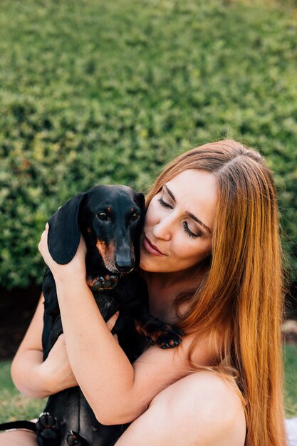 Jeune femme aux cheveux longs embrassant son chien