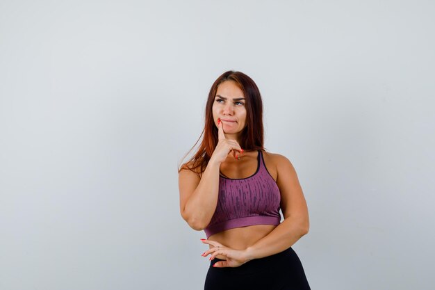 Jeune femme aux cheveux longs portant des vêtements de sport