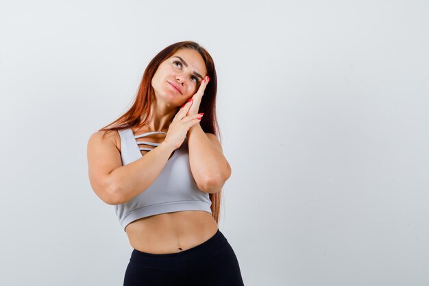 Jeune femme aux cheveux longs portant des vêtements de sport