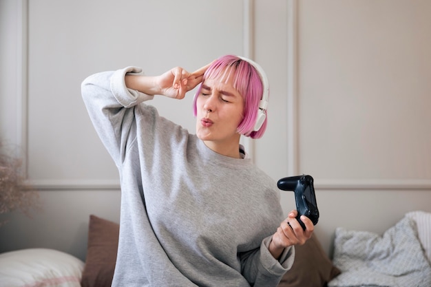 Jeune femme aux cheveux roses jouant à un jeu vidéo