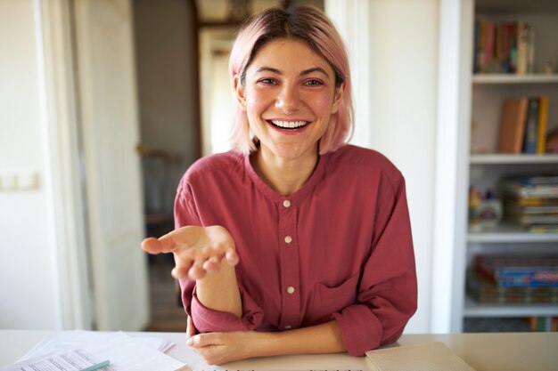 Jeune femme aux cheveux rosés posant