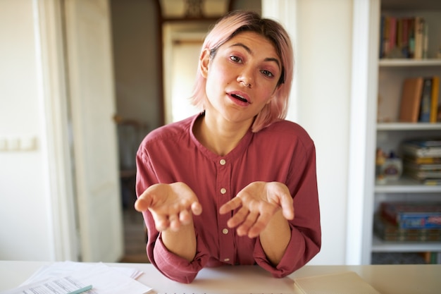 Jeune femme aux cheveux rosés posant