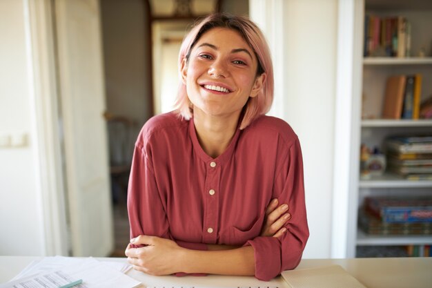 Jeune femme aux cheveux rosés posant