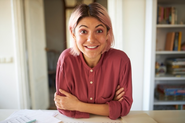 Jeune femme aux cheveux rosés posant