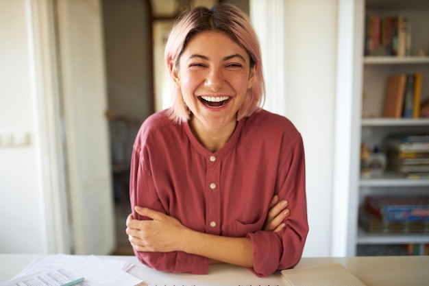 Jeune femme aux cheveux rosés posant