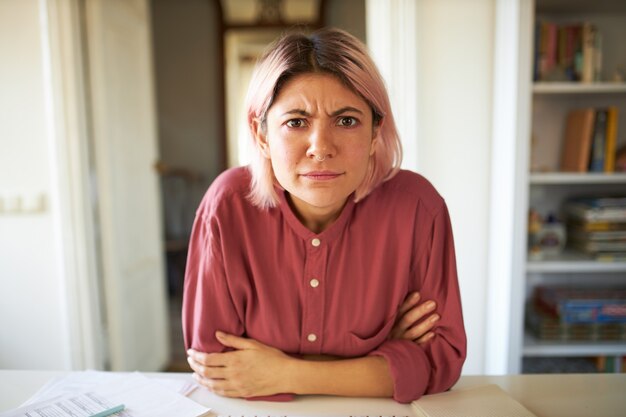 Jeune femme aux cheveux rosés posant