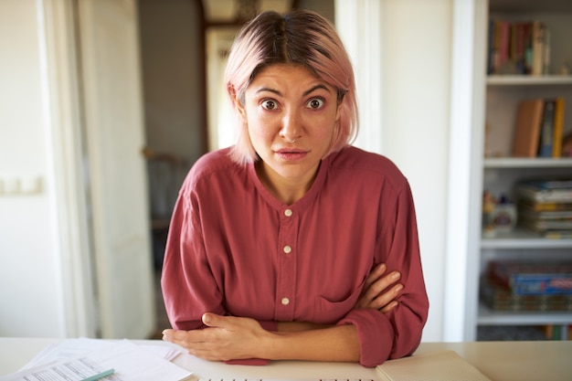 Jeune femme aux cheveux rosés posant