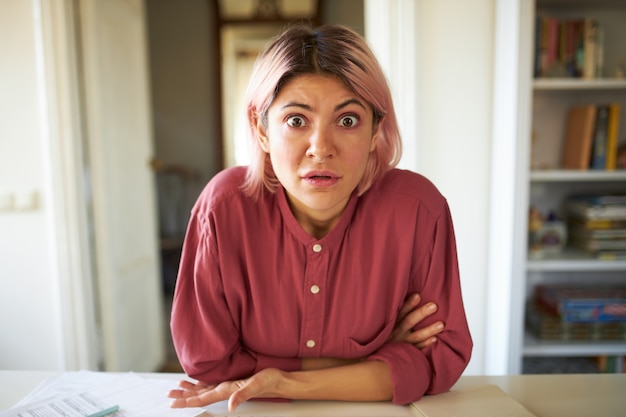 Jeune femme aux cheveux rosés posant