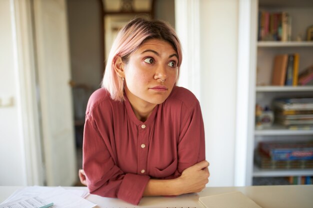 Jeune femme aux cheveux rosés posant