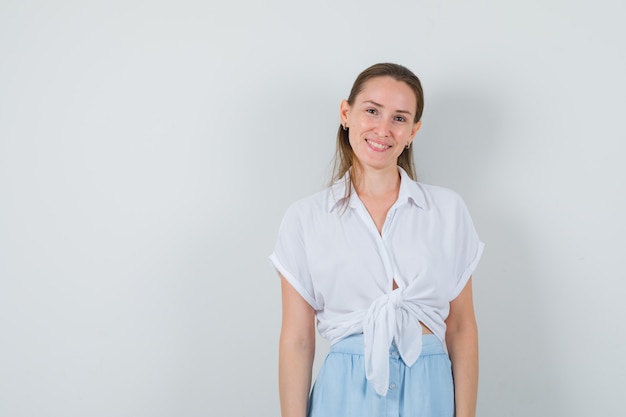 Jeune femme à l'avant en chemisier et jupe et à la séduisante