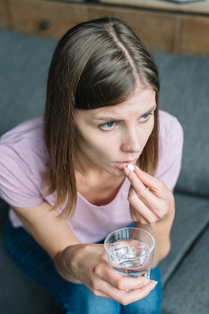 Jeune femme ayant de la fièvre prenant des médicaments