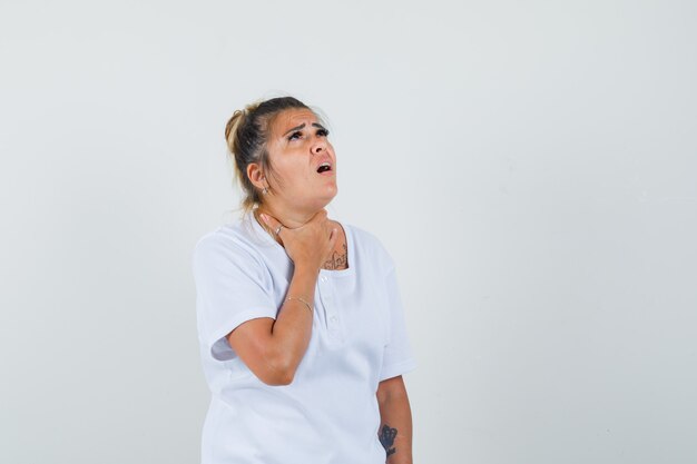 Jeune femme ayant mal à la gorge en t-shirt et à la recherche de mal