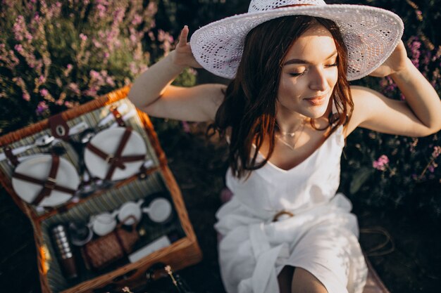 Jeune femme ayant pique-nique dans un champ de lavande