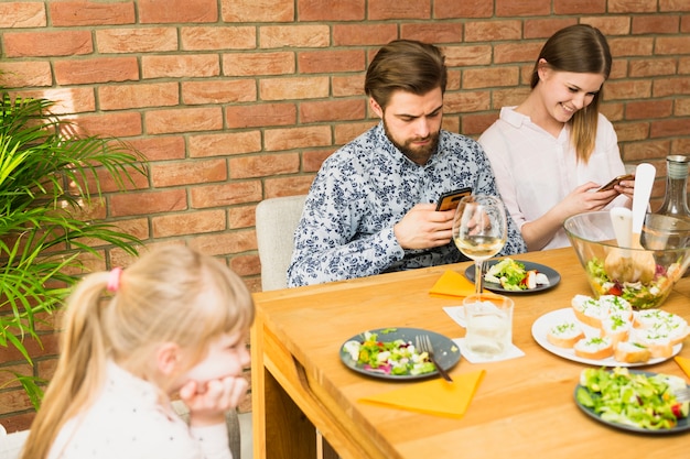 Jeune femme et bel homme assis à table