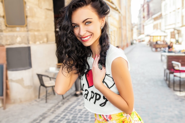 Jeune femme belle hipster marchant sur la rue de la vieille ville