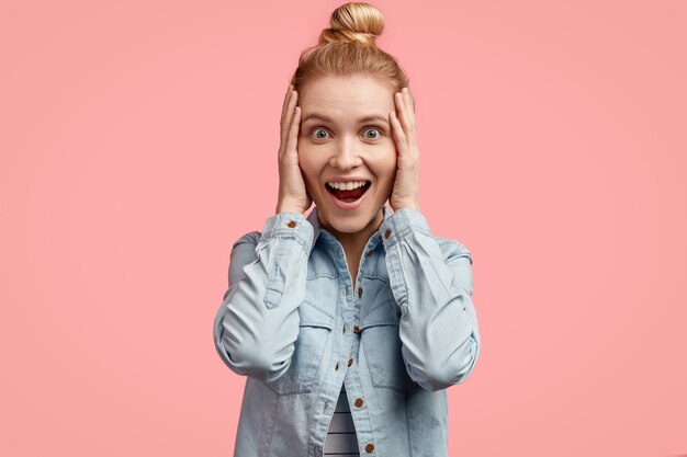 Jeune femme blonde aux cheveux en chignon et portant une veste en jean