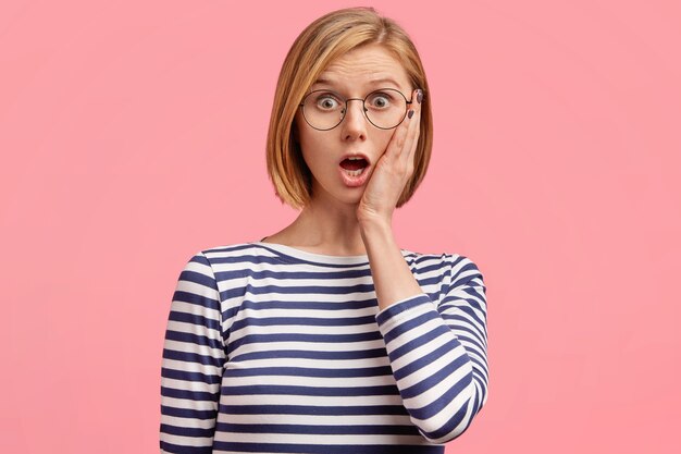 Jeune femme blonde en chemise rayée