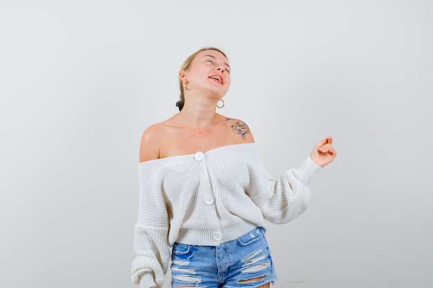 Jeune femme blonde dans un cardigan blanc