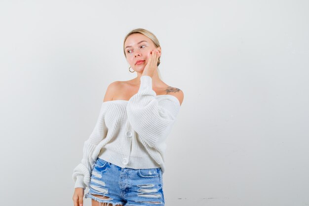 Jeune femme blonde dans un cardigan blanc