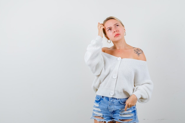 Jeune femme blonde dans un cardigan blanc