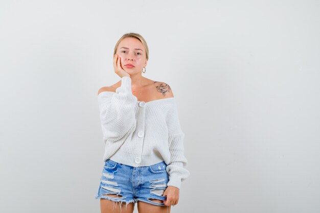 Jeune femme blonde dans un cardigan blanc