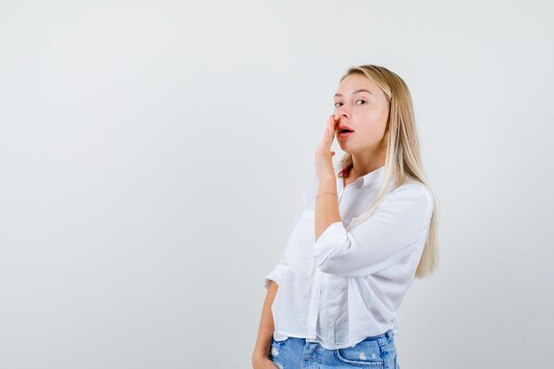 Jeune femme blonde dans une chemise blanche