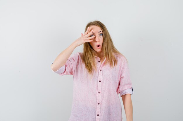 Jeune femme blonde dans une chemise rose décontractée