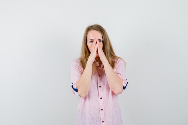 Jeune femme blonde dans une chemise rose décontractée