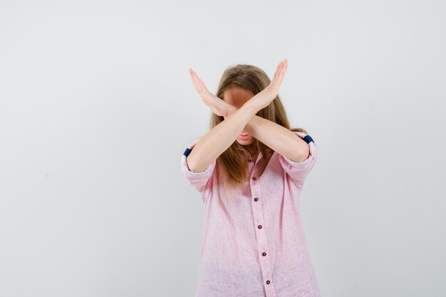 Jeune femme blonde dans une chemise rose décontractée