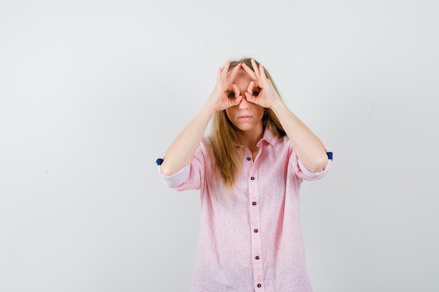 Jeune femme blonde dans une chemise rose décontractée