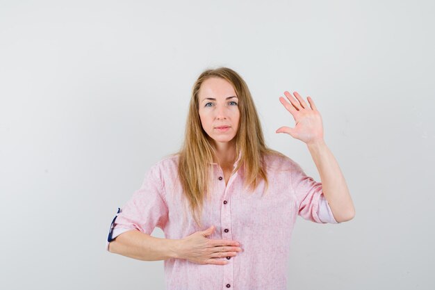 Jeune femme blonde dans une chemise rose décontractée