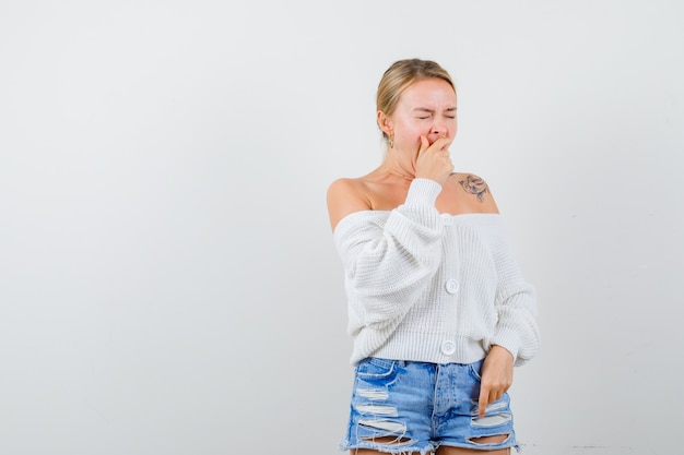 Jeune femme blonde dans un pull blanc