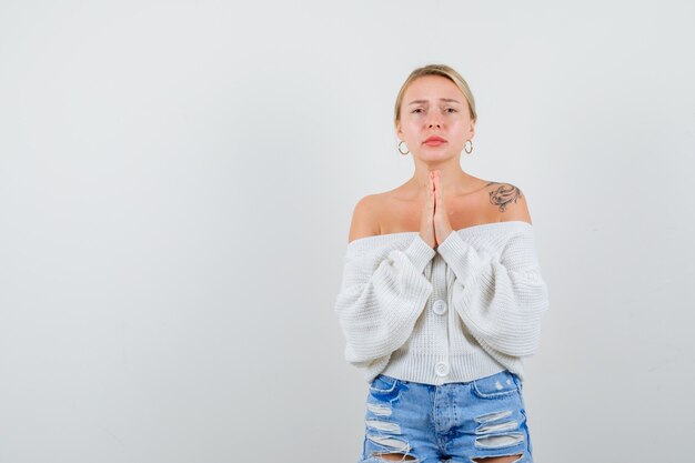 Jeune femme blonde dans un pull blanc