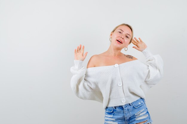 Jeune femme blonde dans un pull blanc