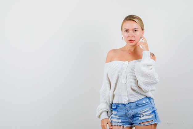 Jeune femme blonde dans un pull blanc