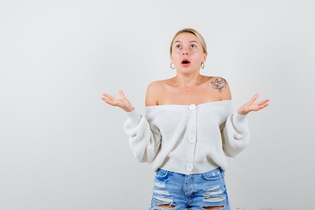 Jeune femme blonde dans un pull blanc