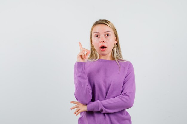 Jeune femme blonde dans un pull violet