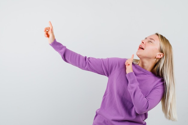 Jeune femme blonde dans un pull violet