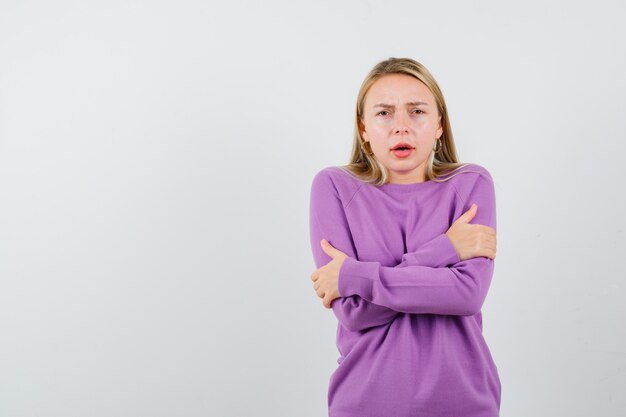 Jeune femme blonde dans un pull violet