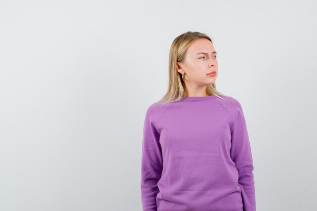 Jeune femme blonde dans un pull violet