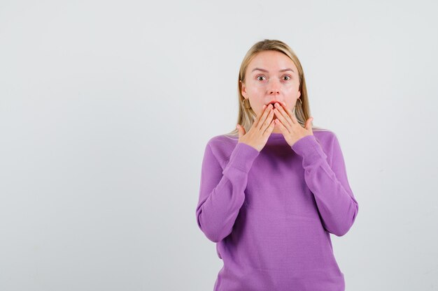 Jeune femme blonde dans un pull violet