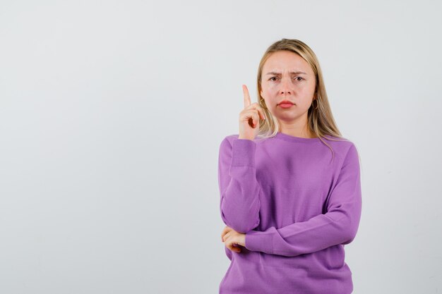 Jeune femme blonde dans un pull violet