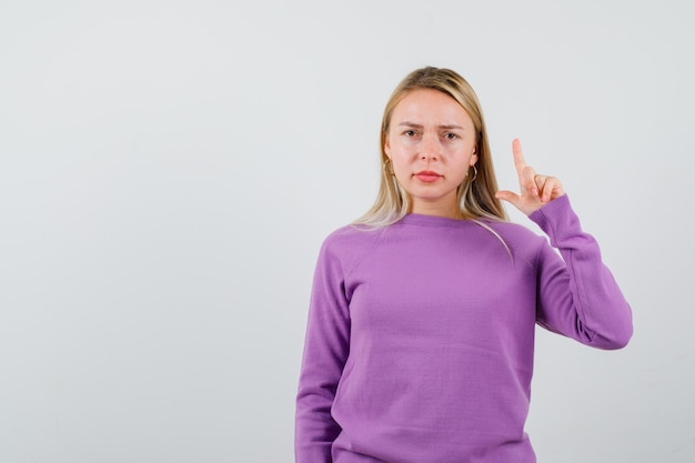 Jeune femme blonde dans un pull violet