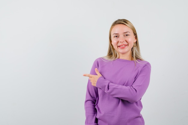 Jeune femme blonde dans un pull violet