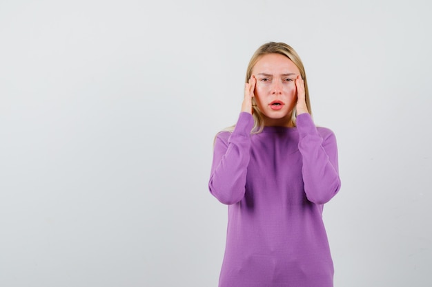 Jeune femme blonde dans un pull violet