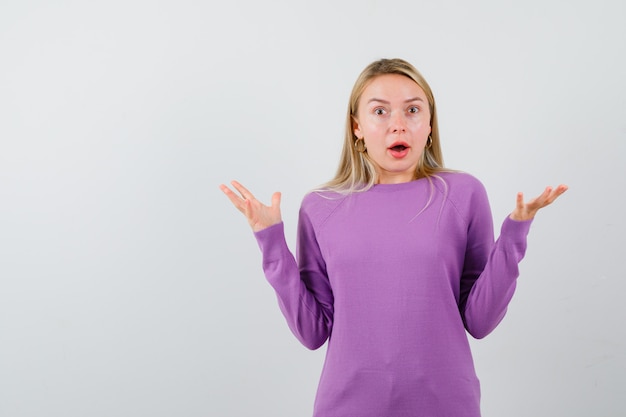 Jeune femme blonde dans un pull violet