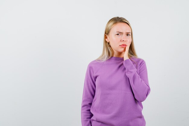 Jeune femme blonde dans un pull violet