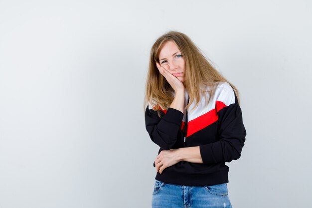 Jeune femme blonde dans une veste et un jean